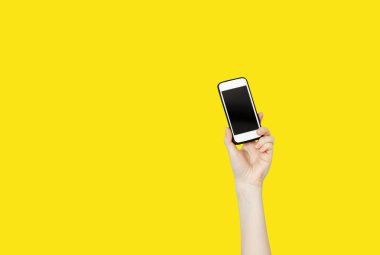 Peson el cep telefonu sarı arka plan üzerinde tutarak