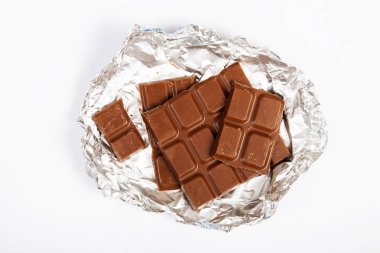 Süt çikolata parçaları beyaz arkaplanda izole edilmiş.