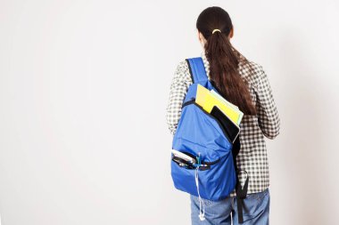 Gri arka plan üzerinde sırt çantası ile öğrenci