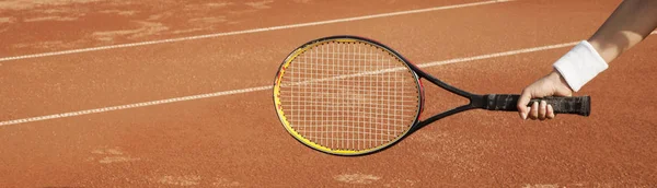 A tennis player prepares to serve a tennis ball during a match