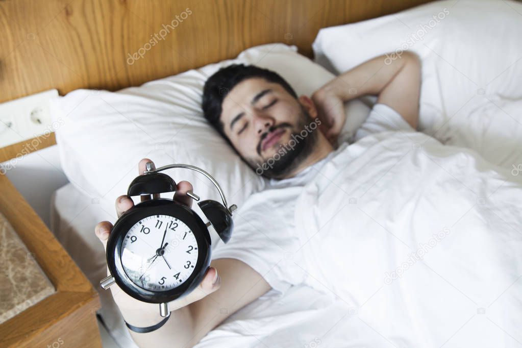 Young man finding it difficult to wake up in the morning