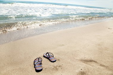 Yaz tatil plaj arka flip ile tropikal bir kumsalda floplar. Terlik bir plajda kum üzerinden rahatla kavramı