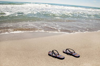 Yaz tatil plaj arka flip ile tropikal bir kumsalda floplar. Terlik bir plajda kum üzerinden rahatla kavramı