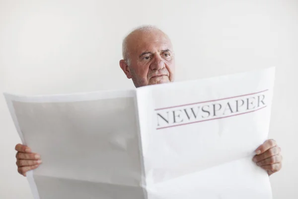 Senior old man reading newspaper.