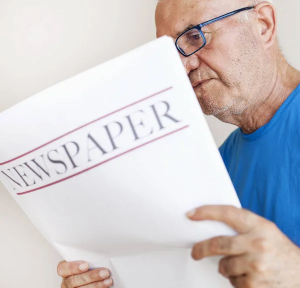 Senior old man reading newspaper.