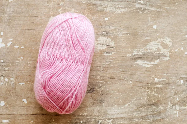 Knitting needles and wool ball isolated on wooden background