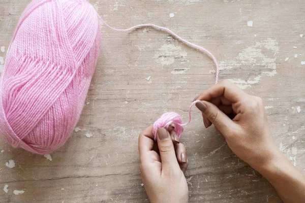 Knitting needles and wool ball isolated on wooden background