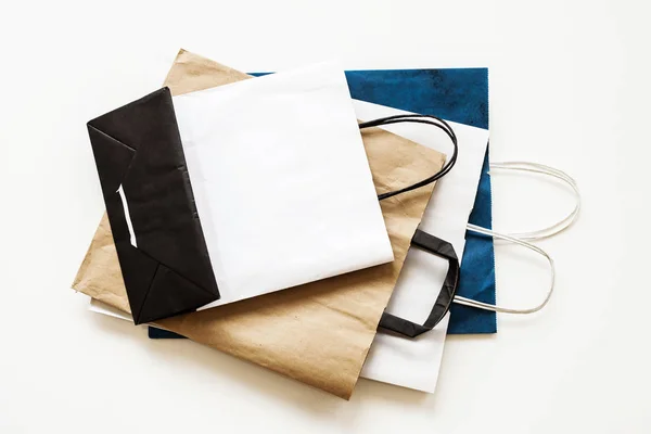 Blank paper carrier bags with handles for shopping.