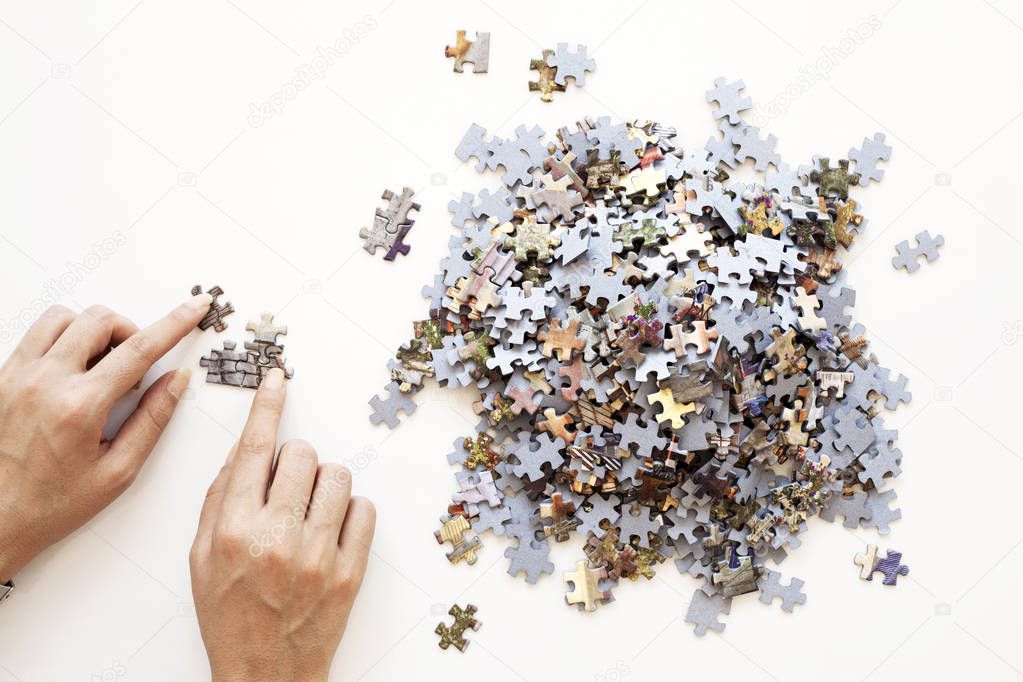 Person hands Unfinished color puzzle pieces on white background. Business concept