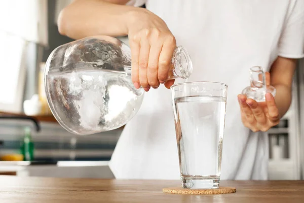 Genç bayan bir bardak su tutuyor. Temiz bir bardaktaki temiz içme suyu ellerinizde..
