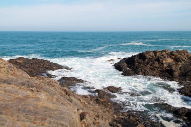 Dalgalar ve mavi gökyüzü güzel sahil şeridine.