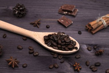 Tahta arka planda tarçın çubukları ve kahve çekirdekleri