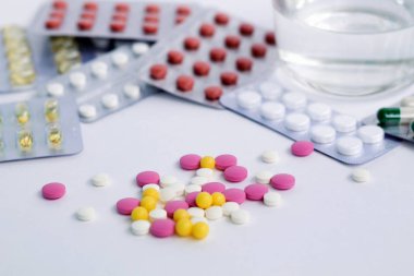 su bardağı ile beyaz arka plan üzerinde renkler hapları