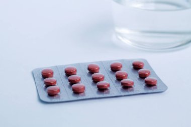 Beyaz arka plan üzerinde izole bir blister içinde kırmızı hapları
