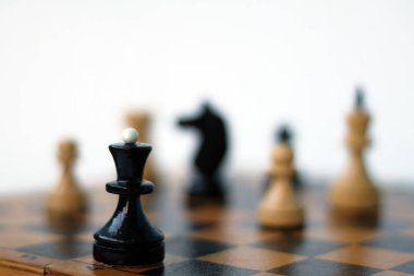 satranç tahtası üzerinde satranç taşları. diğer taşlarla satranç tahtası üzerinde siyah satranç kraliçesi