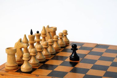 satranç tahtası üzerinde satranç taşları. siyah bir piyon tüm beyaz satranç taşları yüzleri.