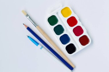 beyaz arka plan üst görünümünde yalıtılmış boya lar ve fırçalar ile palet