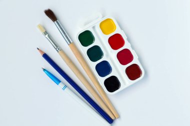 beyaz arka plan üst görünümünde yalıtılmış boyalar ve fırçalar