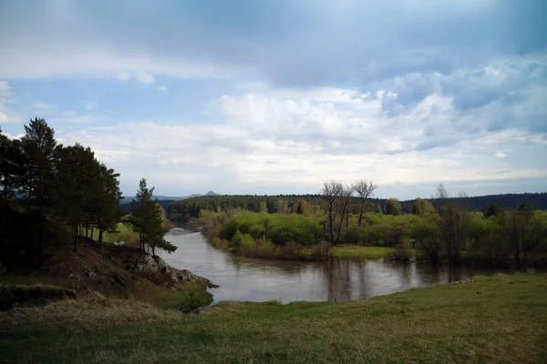 Beautiful landscape with a river and blue sky. The river with green forest after the storm