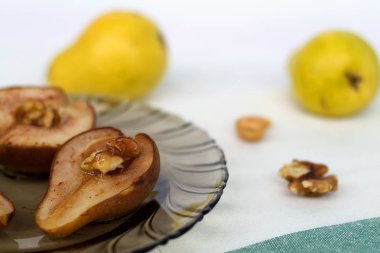 taze meyve ve fındık beyaz arka plan ile koyu cam plaka üzerinde fındık ve bal ile pişmiş armut