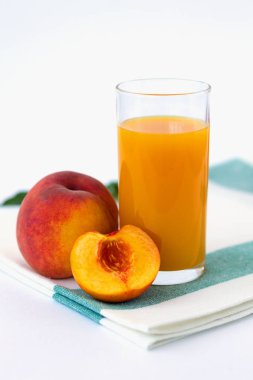 beyaz masada taze meyve suyu ve şeftali cam