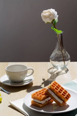 ahşap arka plan üzerinde kahve ve Belçika waffle ve çiçek ile kahvaltı