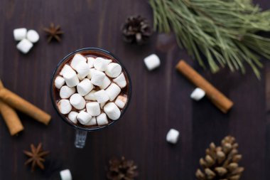 siyah arka plan üst görünümünde noel dekorasyonu ile sıcak çikolata ve mini marshmallow