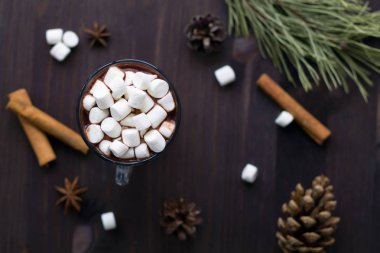 siyah arka plan üst görünümünde noel dekorasyonu ile sıcak çikolata ve mini marshmallow