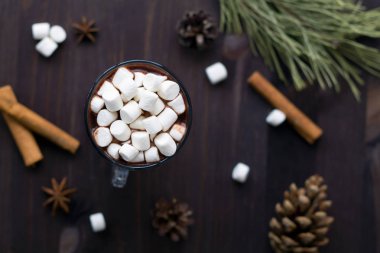 siyah arka plan üst görünümünde noel dekorasyonu ile sıcak çikolata ve mini marshmallow