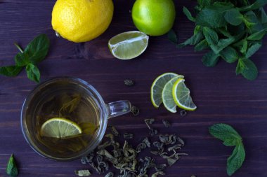 Limonlu yeşil çay ve ahşap arka planda taze nane.