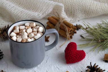 Bir fincan kremalı ve tarçınlı sıcak çikolata, anason yıldızı ve beyaz arka planda kırmızı kalp. Yatay. Kış ve sonbahar sıcak içecekleri