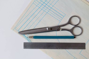 Dikiş işi. Bir moda tasarımcısının beyaz masasında kalem, cetvel, makas ve desenler. Üst Manzara. kopyalama alanı. beyaz arkaplanda ofis araçları