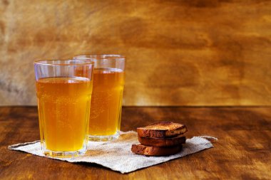 Yaz meşrubatı. İki bardak ev yapımı ekmek ve fotokopi alanı. Tahta bir masanın üzerinde çuval bezli bira ve sert çavdar ekmeği..