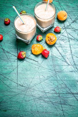 Şeftali, çilek ve çikolata ile güler yüzlü. Rustik arka plan üzerinde.