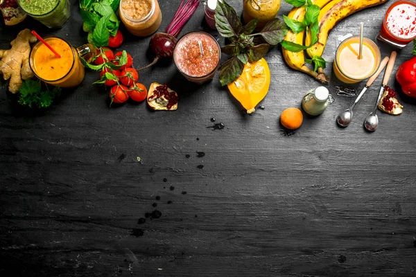 Summer smoothies of vegetables, berries and fruits. On black background.