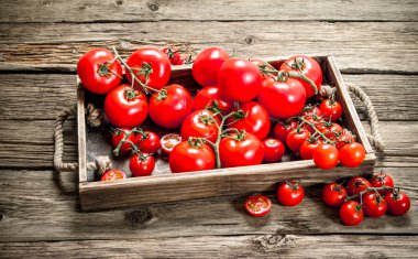 Taze domates içinde ahşap tepsi. Ahşap bir arka plan üzerinde.