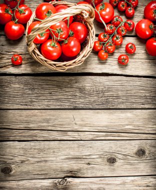 Olgun domates bir sepet içinde. Ahşap bir arka plan üzerinde.