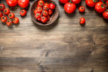 Olgun domates bir kase. Ahşap bir masaya.