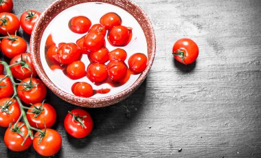 Turşusu domates bir kase. Siyah arka plan üzerine.