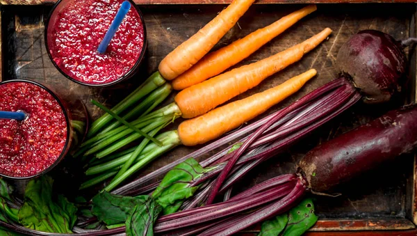 Vegetable smoothie with beets and carrots. On black background.