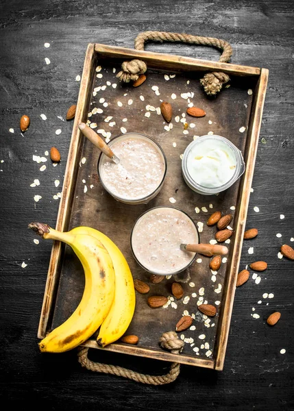 Protein smoothie with banana and nuts. On black background.