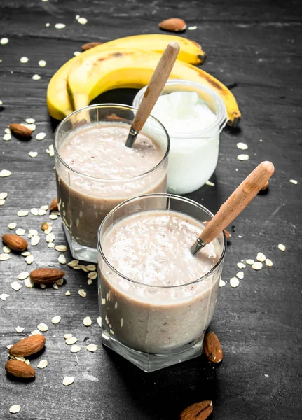 Protein smoothie with banana and nuts. On black background.