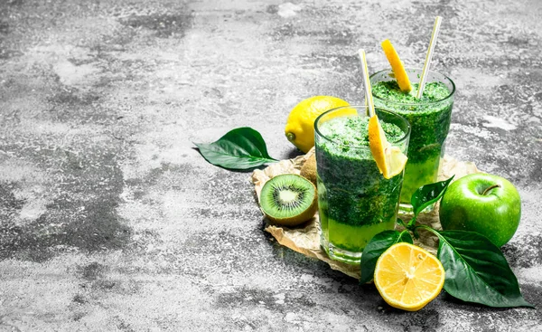 Yeşil elma, kivi ve otlar ile güler yüzlü. Rustik arka plan üzerinde.