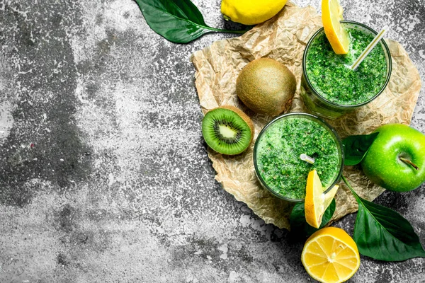 Yeşil elma, kivi ve otlar ile güler yüzlü. Rustik arka plan üzerinde.