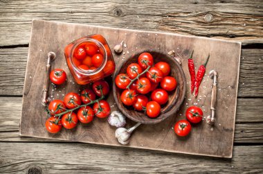 Turşusu domates sarımsak ve baharat ile. Ahşap bir masaya.