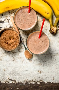 Kakao ve muz ile güler yüzlü. Rustik arka plan üzerinde.