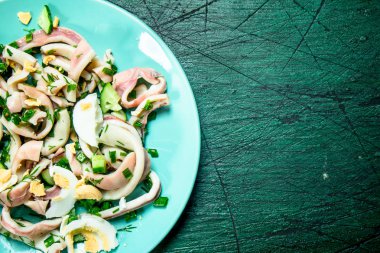 Salata, kalamar, salatalık ve Yeşiller. Rustik arka plan üzerinde.