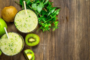 Kivi ve nane ile yeşil güler yüzlü. Ahşap bir arka plan üzerinde.