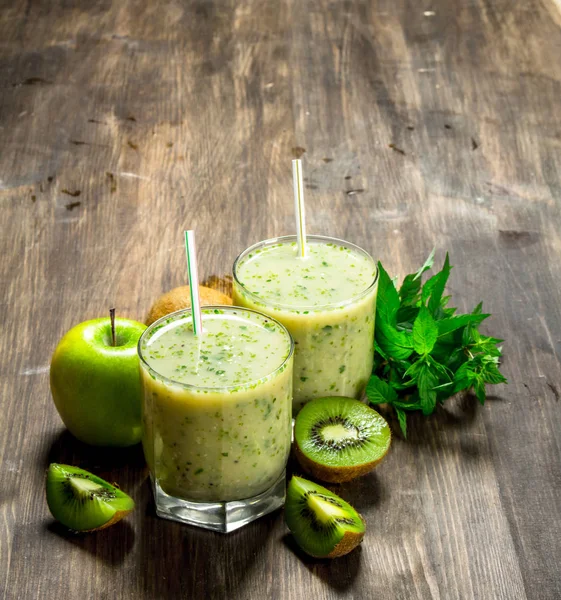 Kivi ve nane ile yeşil güler yüzlü. Ahşap bir arka plan üzerinde.