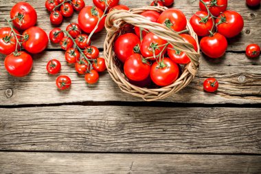 Olgun domates bir sepet içinde. Ahşap bir arka plan üzerinde.